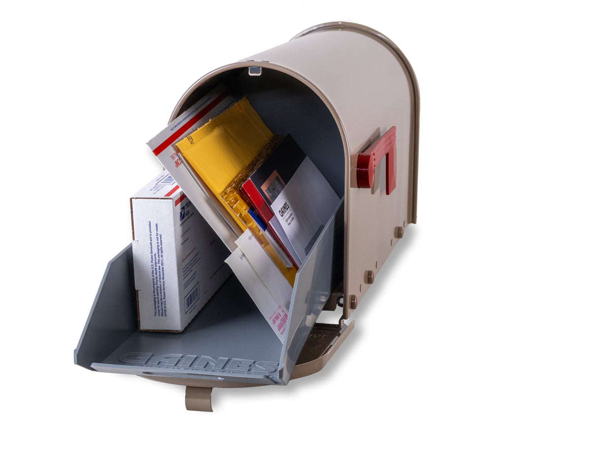 A Janzer Sliding Mailbox Tray by Gaines Manufacturing Inc., displayed in a refined beige finish with its door open to reveal generous interior space, thoughtfully accommodating assorted packages, envelopes, and letters. Crafted from premium, weather-resistant materials for enduring elegance and functionality, this mailbox tray presents a sophisticated solution that enhances curb appeal within upscale residential settings. Set against a white background for optimal visual clarity.