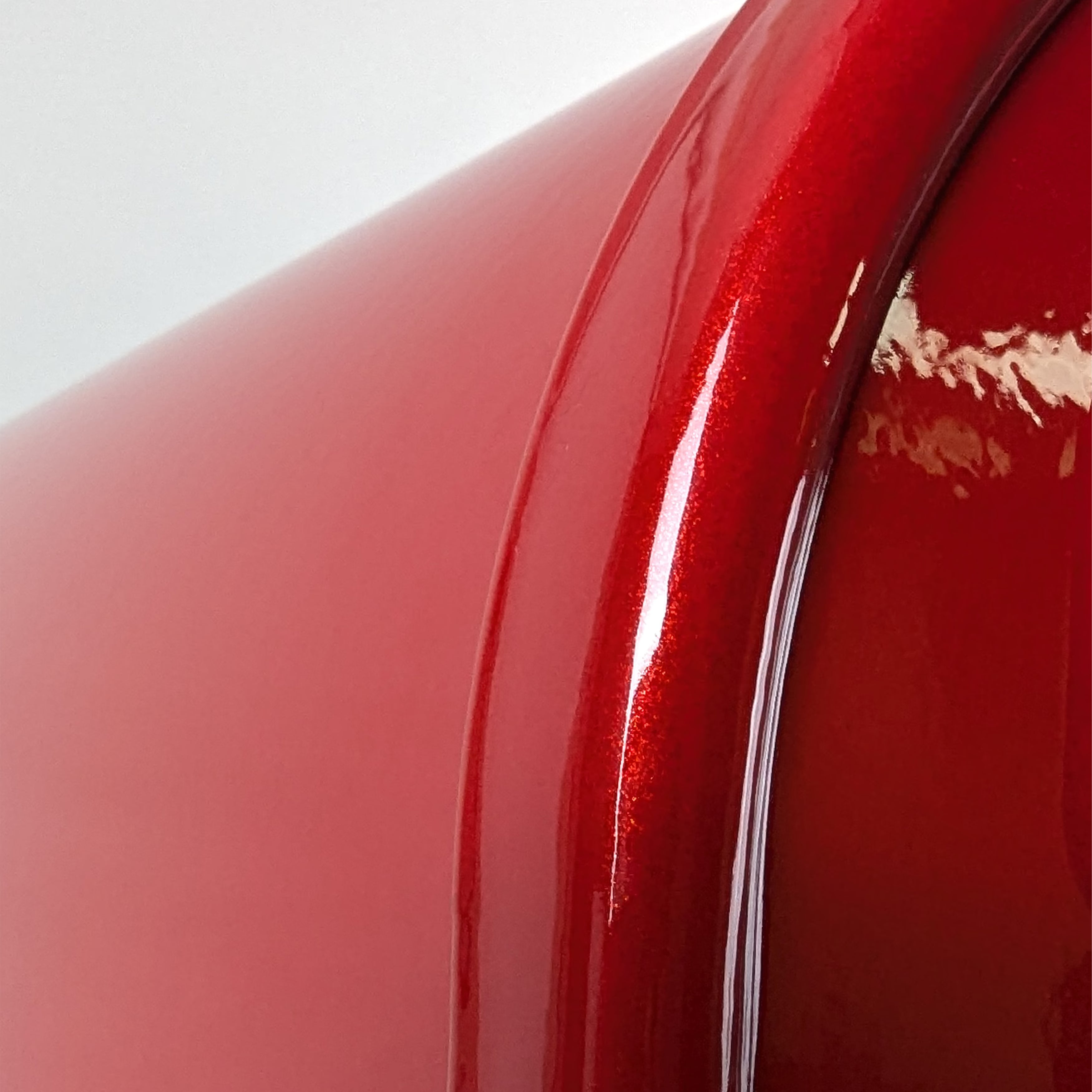 Close-up of the Limited Edition: Red Clear Coat Sparkle Janzer Mailbox by Gaines Manufacturing Inc, highlighting its expertly crafted, lustrous red exterior with a premium glossy finish. The superior materials and refined curvature reflect light elegantly, conveying exceptional durability and upscale curb appeal designed for discerning homeowners and prestigious HOAs.